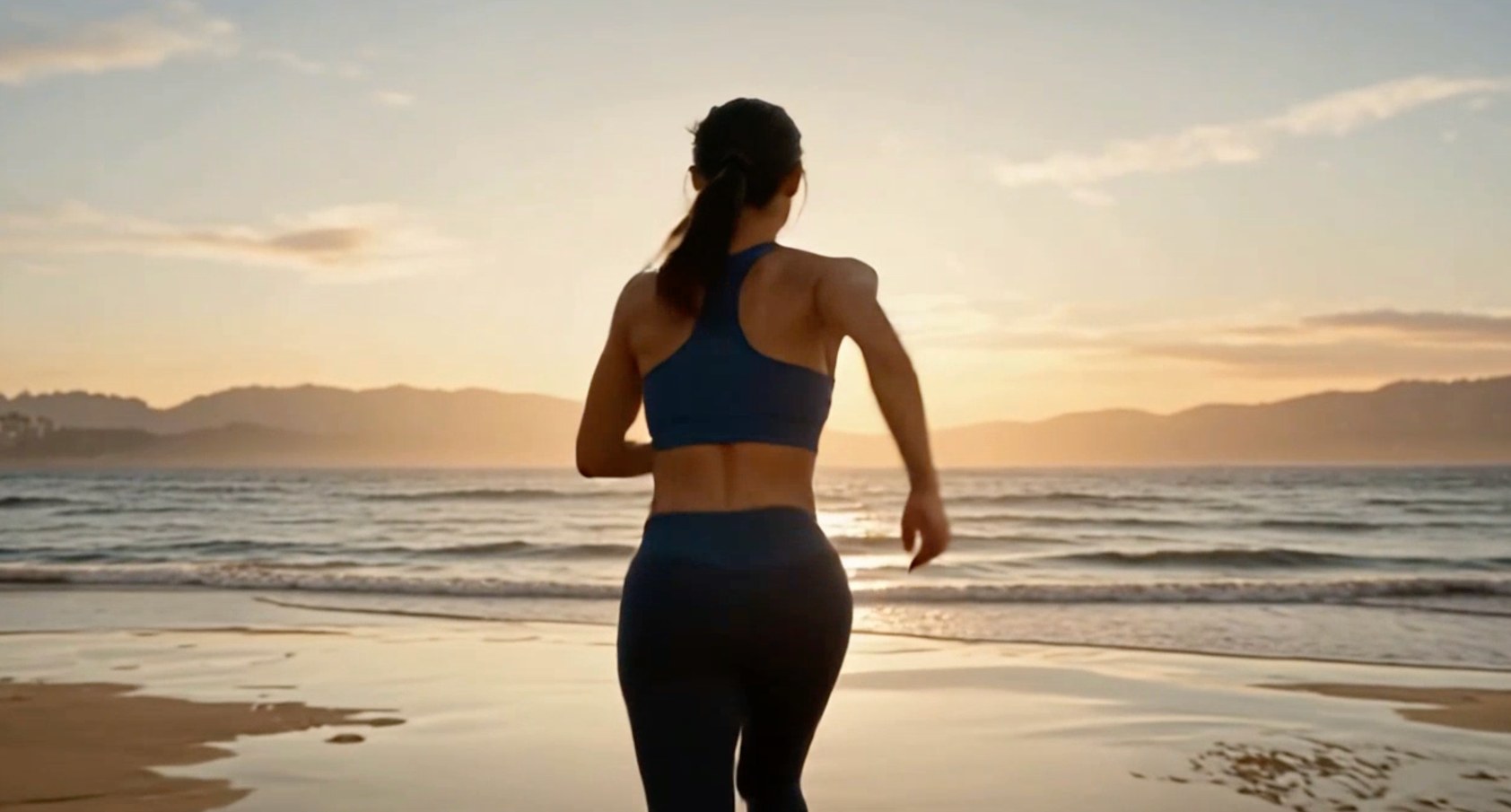 A woman running on the beach at sunrise